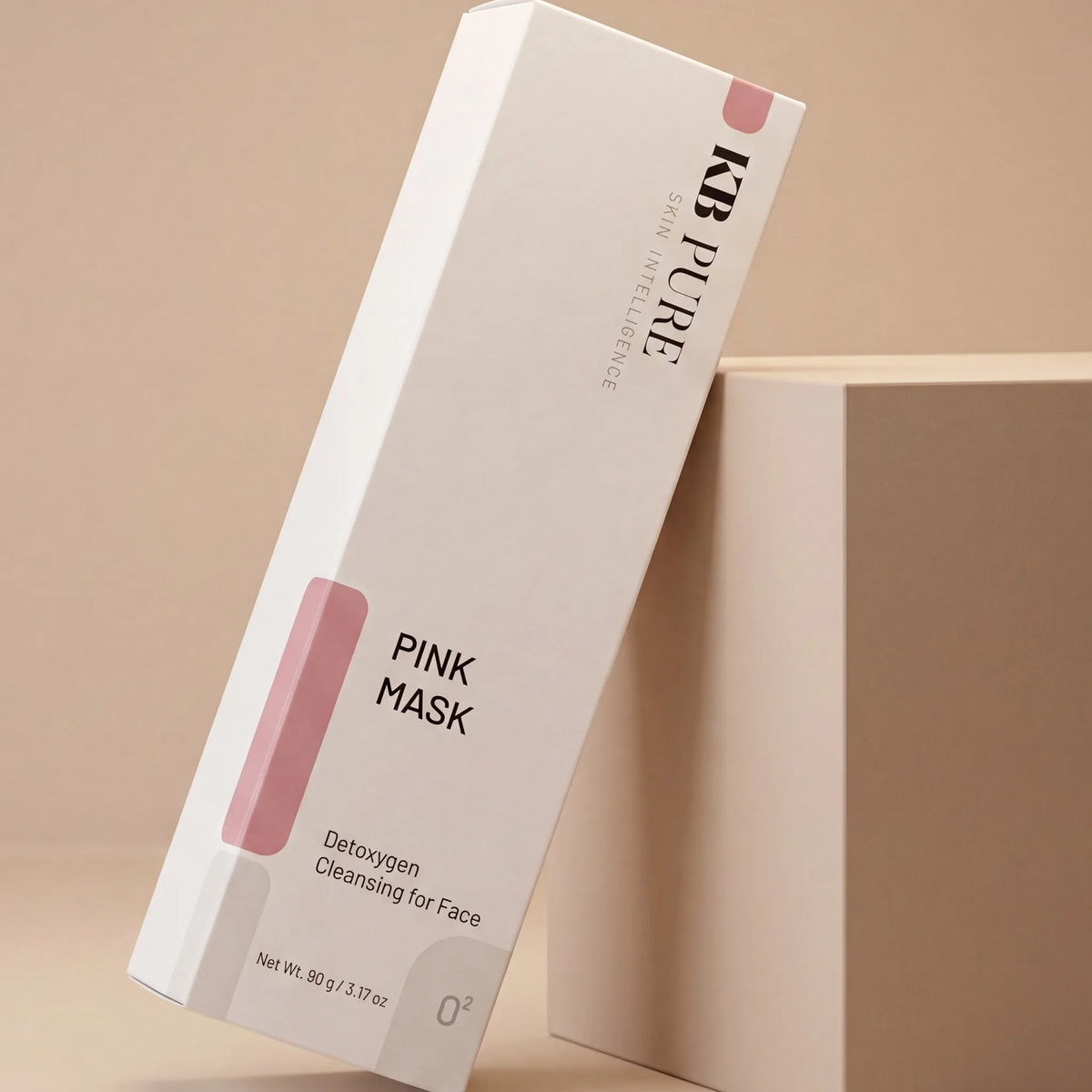 אריזת דארק מאסק גרסה ורודה (Pink Mask) של KB Pure נשענת על קובייה בגוון בז׳