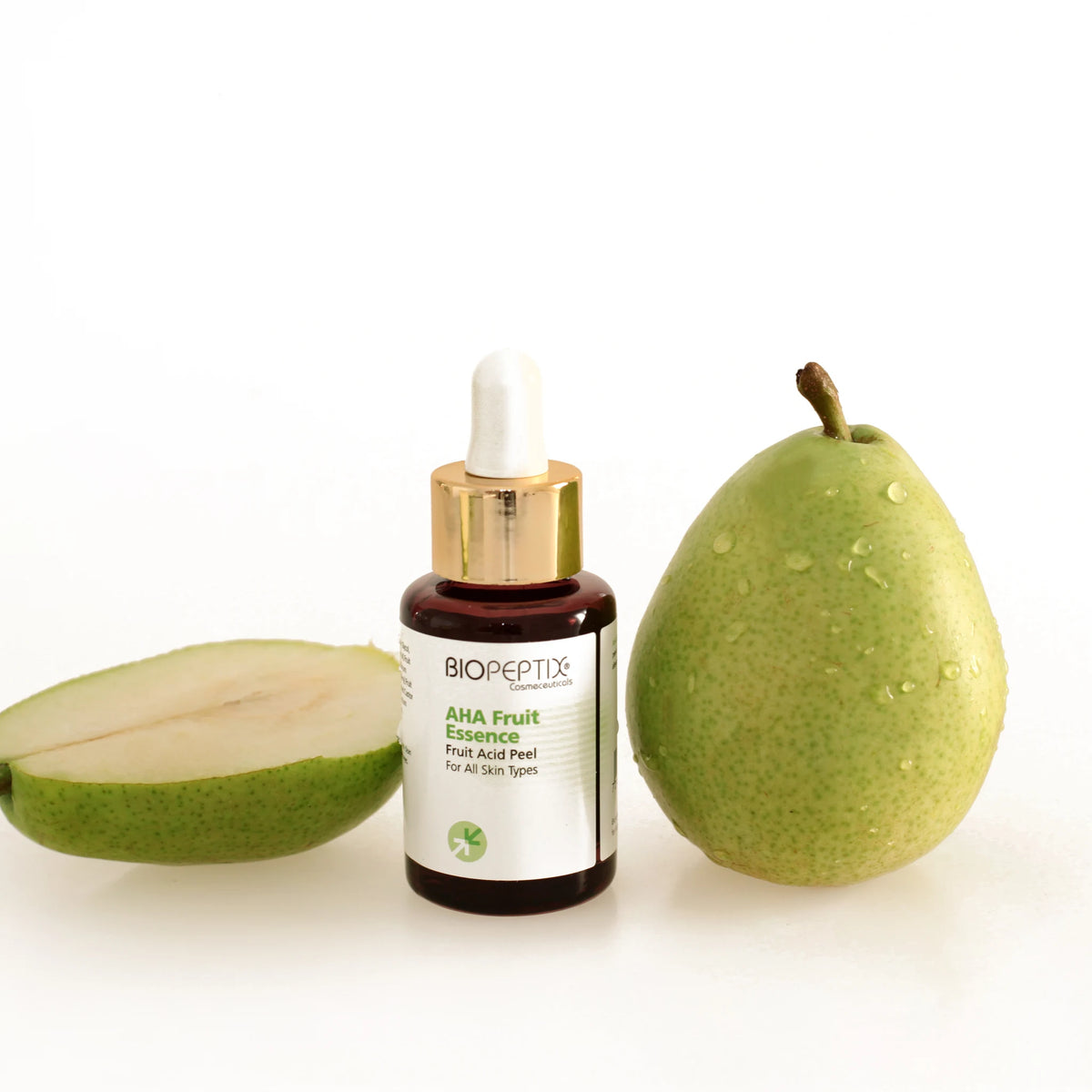 סרום חומצת פירות AHA Fruit Essence של Biopeptix, בקבוק טפטפת לצד אגס ירוק וחצי אגס